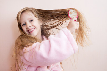 Wall Mural - little girl combs her hair after a shower