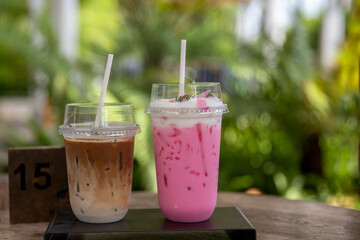 iced Pink milk, Thai style iced sweet milk with cider syrup and iced  latte coffee  on the wooden table