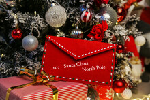 An Envelope With A Letter To Santa Claus Under The Christmas Tree