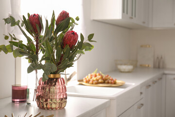 Canvas Print - Beautiful protea flowers on countertop in kitchen, space for text. Interior design