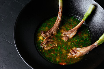 Wall Mural - meat soup with a rack of lamb on a black background