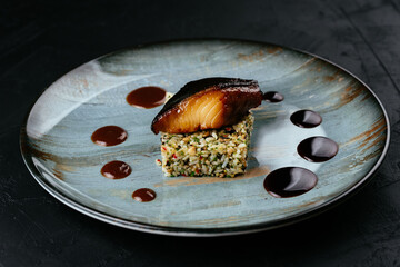 Wall Mural - grilled fish with rice and vegetables on a black background
