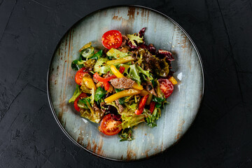 Wall Mural - warm salad with marbled beef steak on a black background