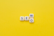 SEM Or SEO Words Made With Letters Of A Board Game, Over A Yellow Background. Search Engine Concepts