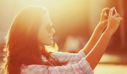 Wall Mural - Portrait of beautiful woman taking selfie picture by phone in summer sunny evening