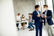 © BGStock72 - Two young business men with facial protective masks discussing  with paper plan in the office