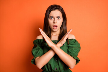 Sticker - Portrait of sad woman show stop gesture wear dark shirt isolated on orange color background