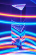 Glass Prism with reflection on a abstract colorful neon stripey background