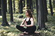 © serbogachuk - Young girl practices yoga in the forest, the concept of enjoying privacy and concentration