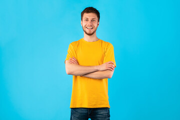 Wall Mural - Confident man posing with folded arms and looking at camera