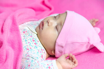 Poster - Baby sleeps on a pink bed. Selective focus.