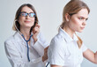 © SHOTPRIME STUDIO - the patient turned her back to the doctor in a medical gown with a stethoscope