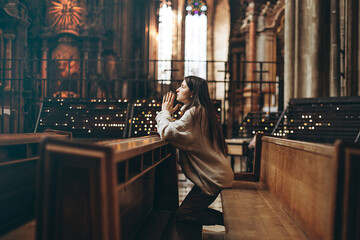 Wall Mural - Christian woman prays in church. Hands crossed on wooden table. Christian Background