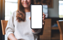 Mockup Image Of A Beautiful Asian Woman Holding And Showing A Mobile Phone With Blank White Screen