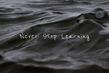 Never Stop Learning Quote On A Water Wave Background