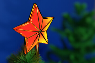 Sticker - 3d illustration a christmas decorative  star on the top of a christmas tree with a beautiful bokeh background. Attributes of Christmas and New Year.