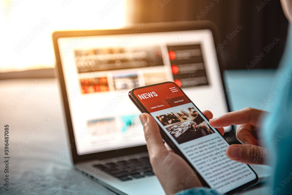 Online news on a smartphone. Mockup website. Woman reading news or articles in a mobile phone screen application at home. Newspaper and portal on internet. - obrazy, fototapety, plakaty 