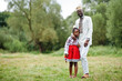 © AS Photo Family - African father with daughter in traditional clothes at park.