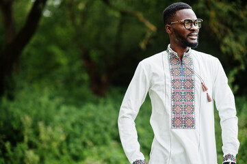 Portrait of african man in traditional clothes at park.