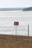 Fototapeta Do pokoju - beach with a volleyball court and a swimming sign is not allowed
