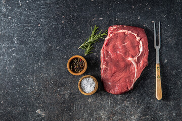 Wall Mural - Sliced raw ribeye steak on black kitchen table.