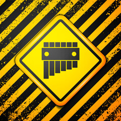 Black Pan flute icon isolated on yellow background. Traditional peruvian musical instrument. Folk instrument from Peru, Bolivia and Mexico. Warning sign. Vector.