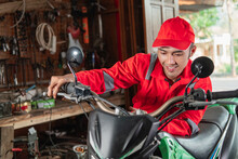 Mechanic In A Wearpack Checks The Engine Throttle Of The Dirt Bike In The Garage