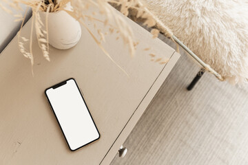 Wall Mural - Flatlay of blank screen mobile phone on beige pastel table. Flat lay, top view. Copy space mockup template.