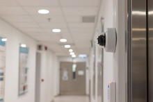 Security Surveillance System (camera And Digital Smart Door Lock) At The Entrance To A Modern Office Building Or Advanced Laboratory With Blurred Corridor