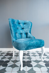 Modern design home interior with elegant blue chair in retro style over gray wall. Stylish home decor