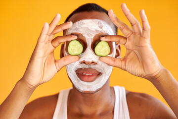 portrait of funny african amercan guy with mask on face and cucumber slices isolated on yellow background, portrait