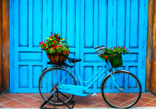 Decorative Blue Vintage Bicycle Decorated With Flower Pots On The Street Of City