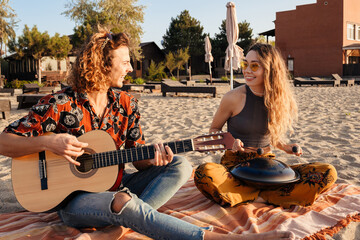 Sticker - Loving couple playing music on guitar and drum at the beach