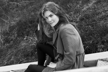 woman with long hair sitting in the park