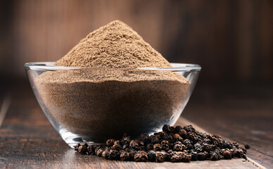 Wall Mural - Composition with bowl of ground black pepper on wooden table