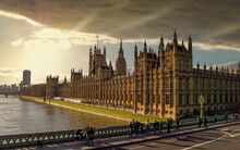 London England, The British Parliament And Thames River Under Dramatic Sky