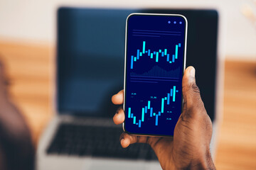 Poster - Trading And Investment. Black Businessman Holding Smartphone With Financial Stock Market Chart