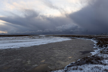 Wall Mural - Arctic landscape in winter time. Small river with ice in tundra.