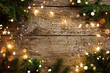 Merry Christmas frame made of Christmas decorations, fir branches, spruce, lights garland, snowflakes on wooden background. Xmas and New Year holiday, bokeh, light. Flat lay, top view