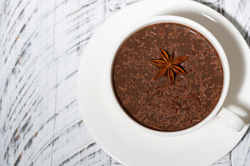 Wall Mural - cup of hot spiced chocolate on white background, top view