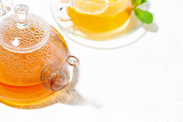 glass teapot with hot tea and lemon