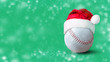 Baseball ball in Santa hat, on a green background. Copy space. Snow effect.
