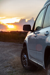 Wall Mural - white suv car on sunset at the field