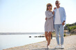© New Africa - Happy couple walking along waterfront on summer day