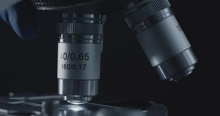 Wall Mural - close-up shot of sample slide and microscope with metal lens at laboratory.