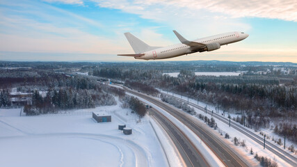 A passenger plane landing at Oslo Gardermoen International Airport - Airport in a snow covered - Beautiful winter landscape with aerial view of highway road and snow-covered road