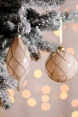 Christmas tree decorated with holiday baubles against blurred lights, closeup
