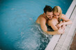 © BGStock72 - Young couple relaxing on the poolside of interior swimming pool