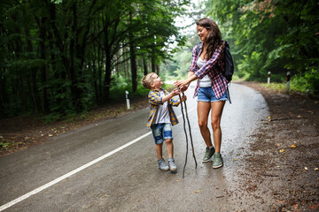Wall Mural - mother and her little sons hiking by the rural country road.outdoor spring leisure concept.