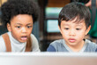 © winnievinzence - Diversity kid watching cartoon on laptop. African American black boy and Asian friend learning and playing together. interracial friendship concept